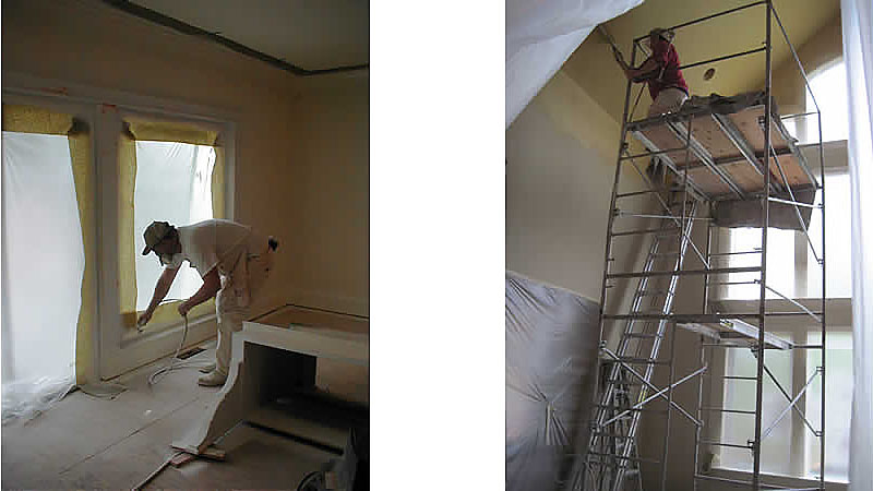 Two workers painting interior with scaffolding