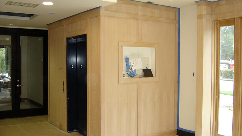 Wood-paneled lobby under renovation with elevators