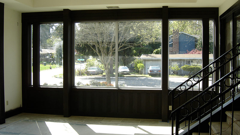Empty room with large windows overlooking street