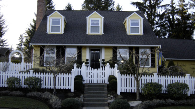 Yellow house with white picket fence