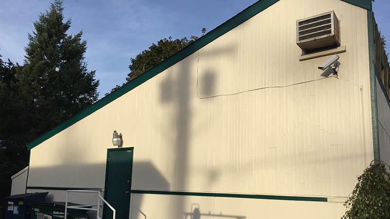 Cream building with green trim and shadow