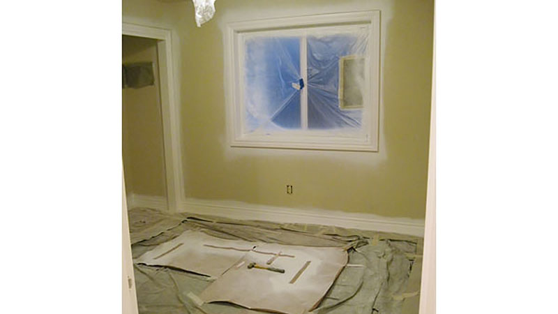 Room under renovation with window covered in plastic