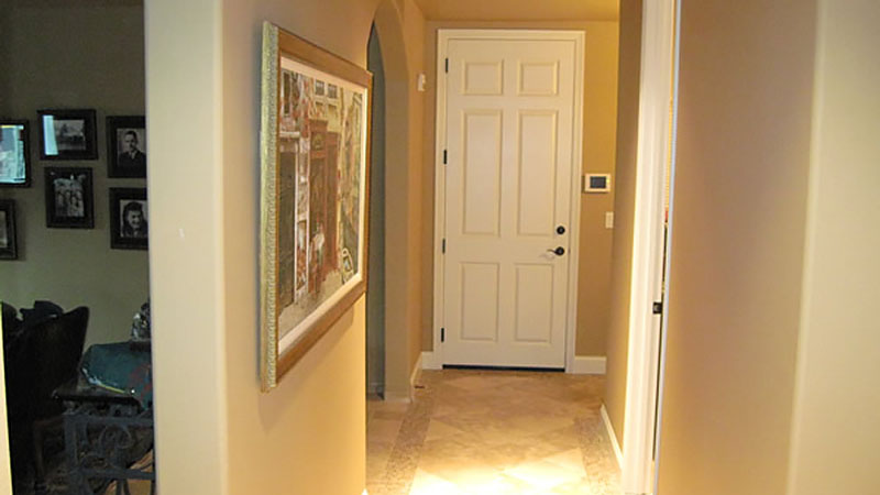 Hallway leading to closed white interior door