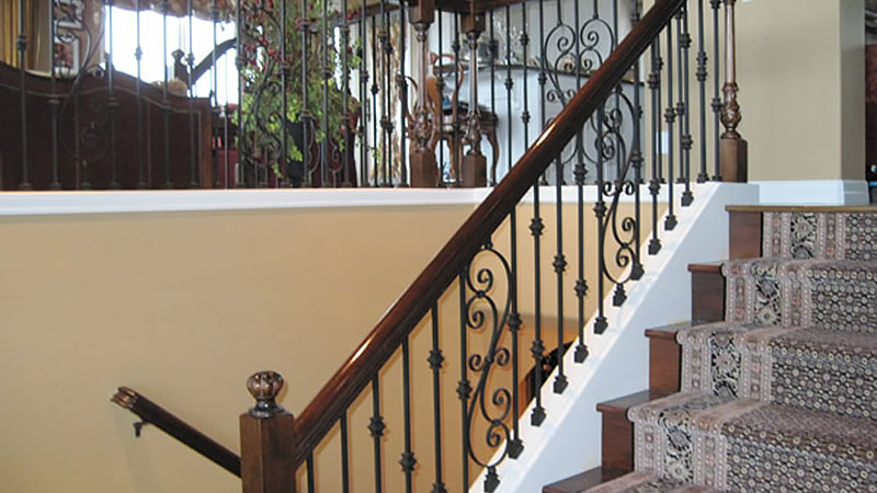 Ornate wooden staircase with patterned carpet runner
