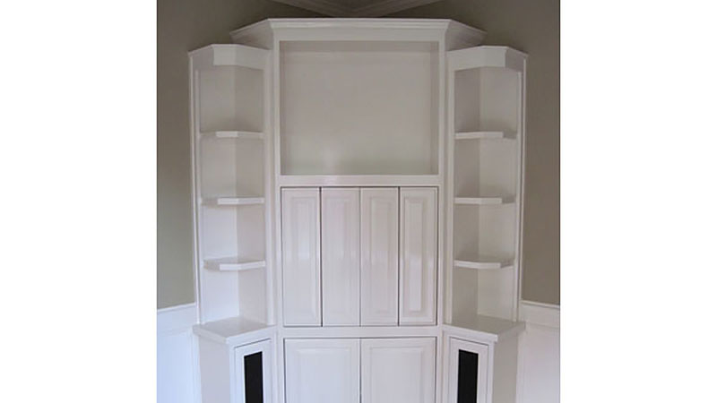 White built-in corner shelves with cabinets
