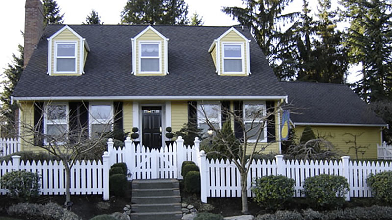 Yellow house with white picket fence