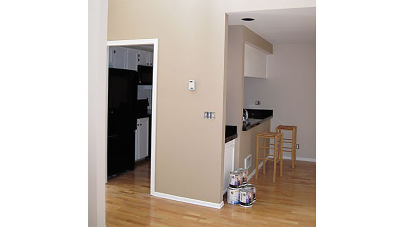 Open-plan apartment with hardwood floors, paint cans