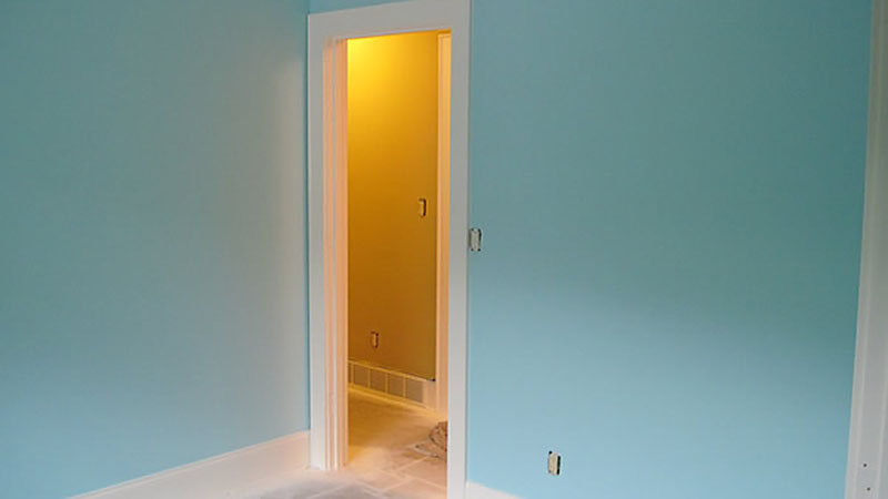 Unfurnished turquoise room with open doorway to hallway