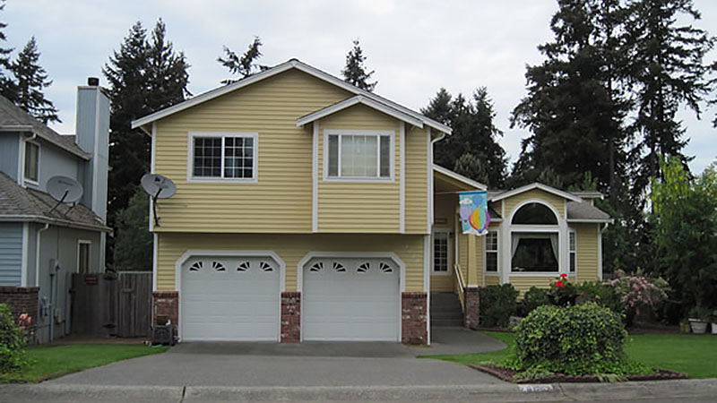 Yellow two-story suburban house with double garage