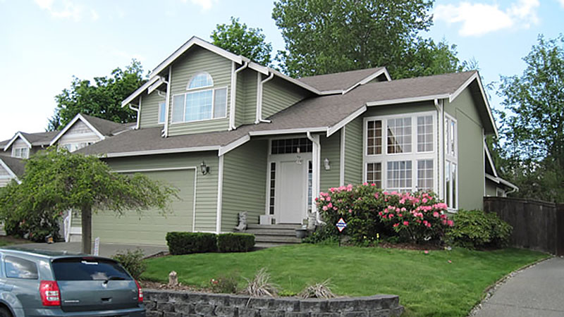 Green two-story suburban house with garage