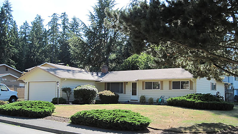 Ranch-style house with lawn and shrubs