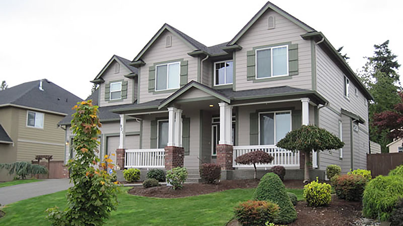 Two-story gray suburban house with landscaped yard