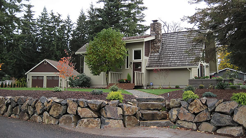 House with stone retaining wall and garage