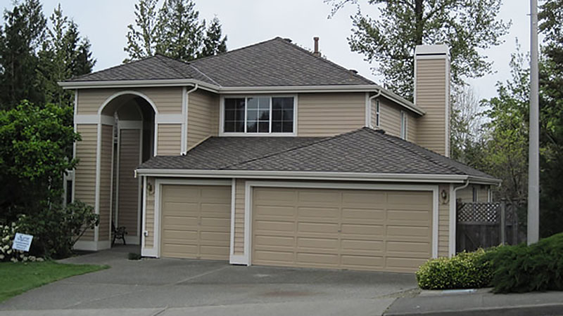 Beige two-story suburban house with three-car garage