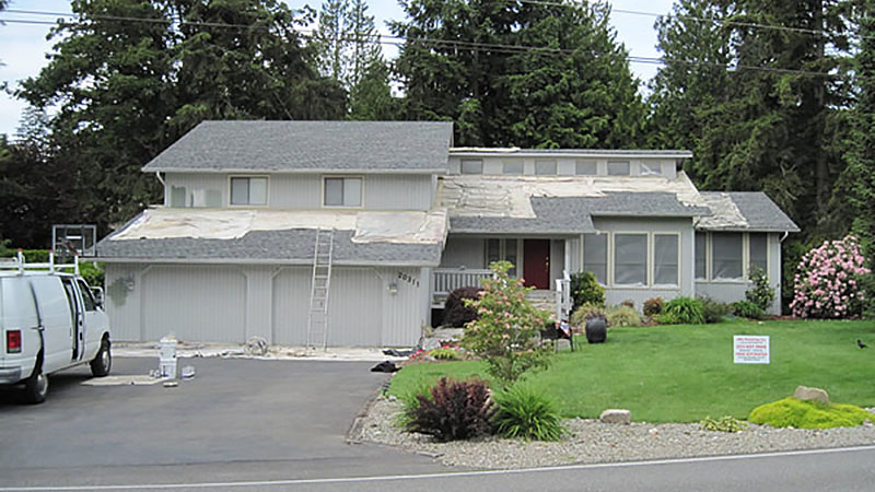 Two-story suburban house with roof repair in progress