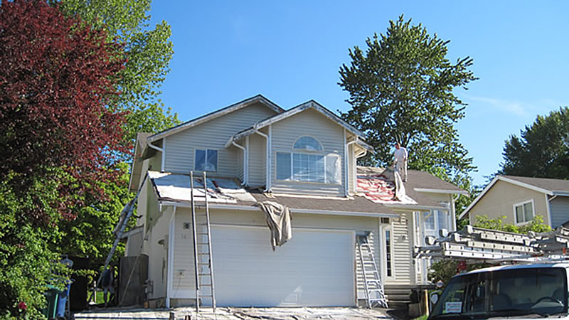 Two-story house roof repair with ladders