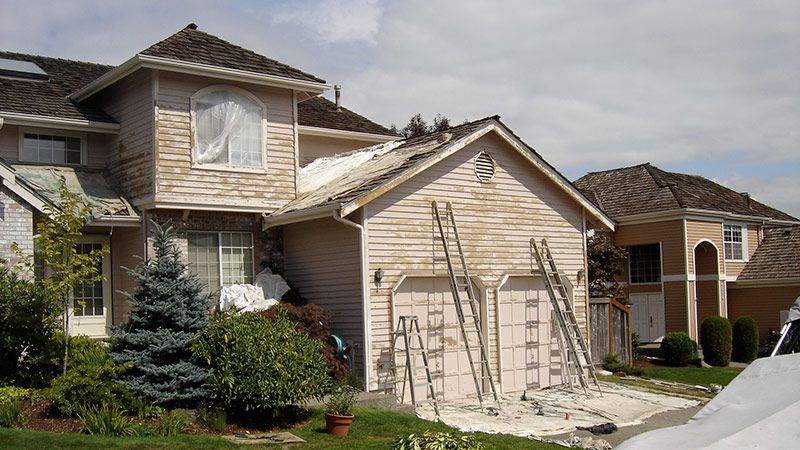 House exterior being repainted with ladders