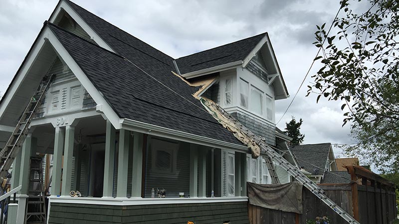 House roof under repair with ladders