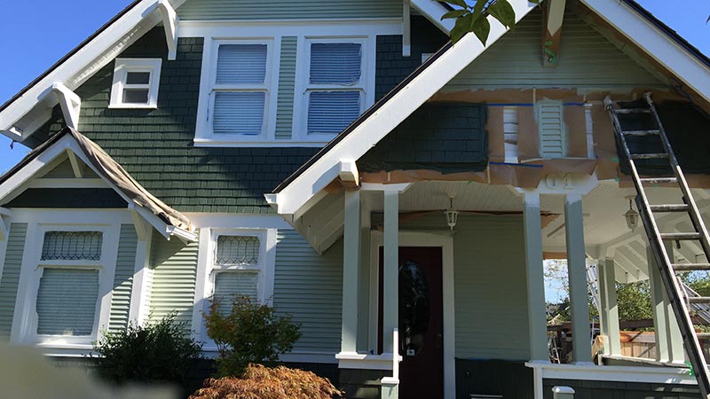 Green house exterior with ladder and porch