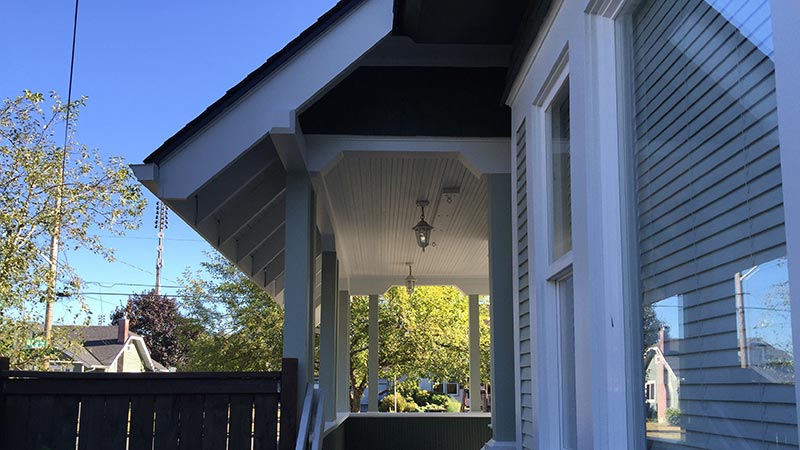 Covered front porch with hanging lantern and fence