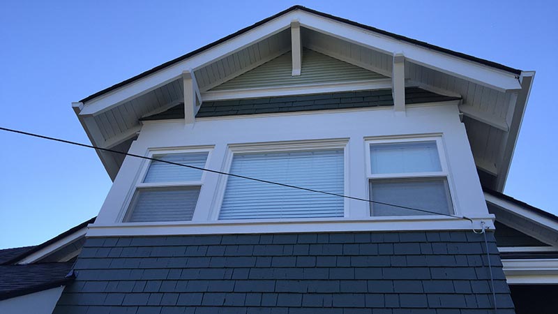 Upper facade of blue-gray shingled house
