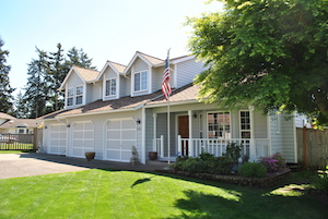 Two story suburban house with garage and flag